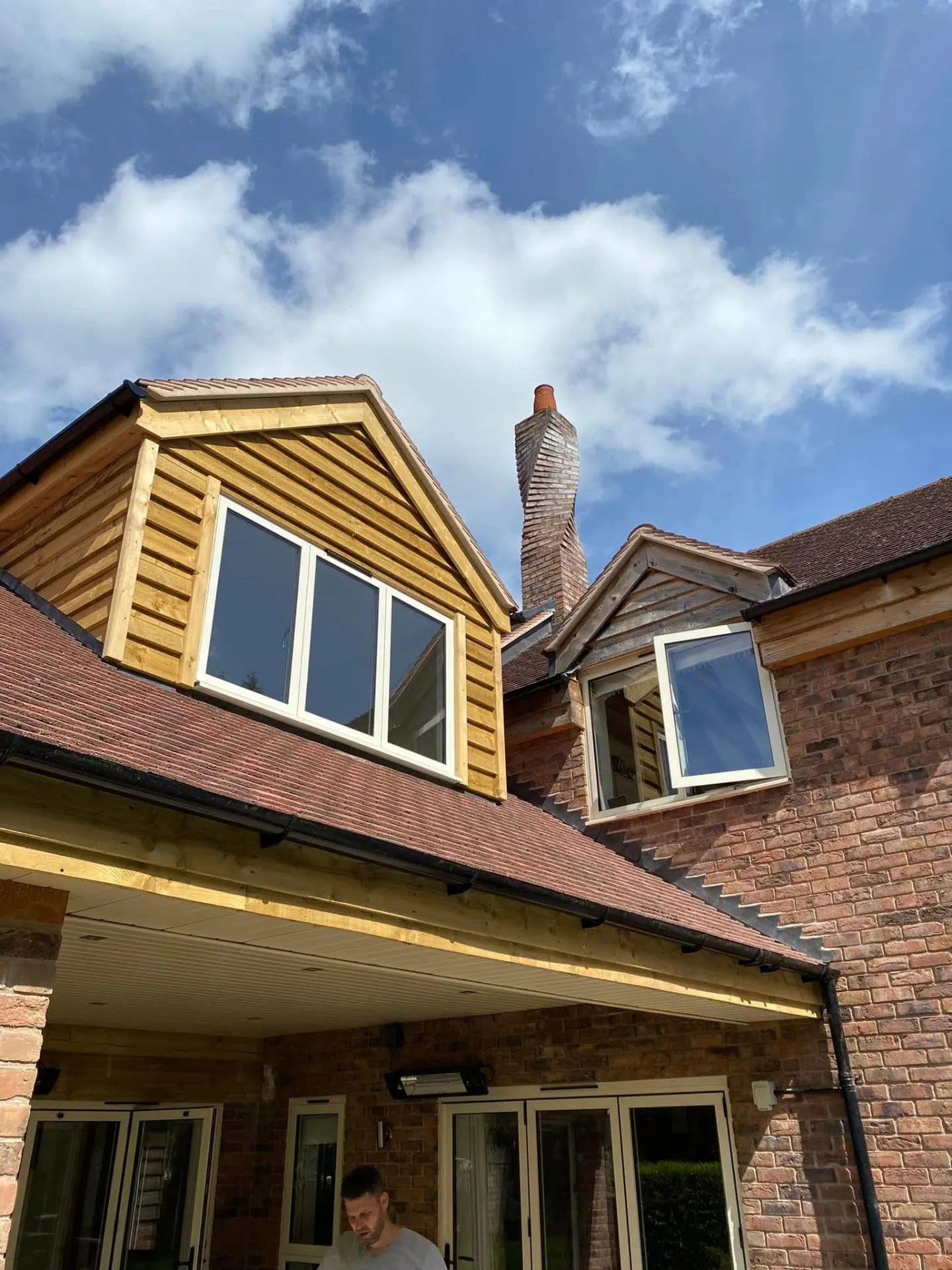 Oak-clad dormers and corbelled brick chimney at Dingleside by JRC Developers