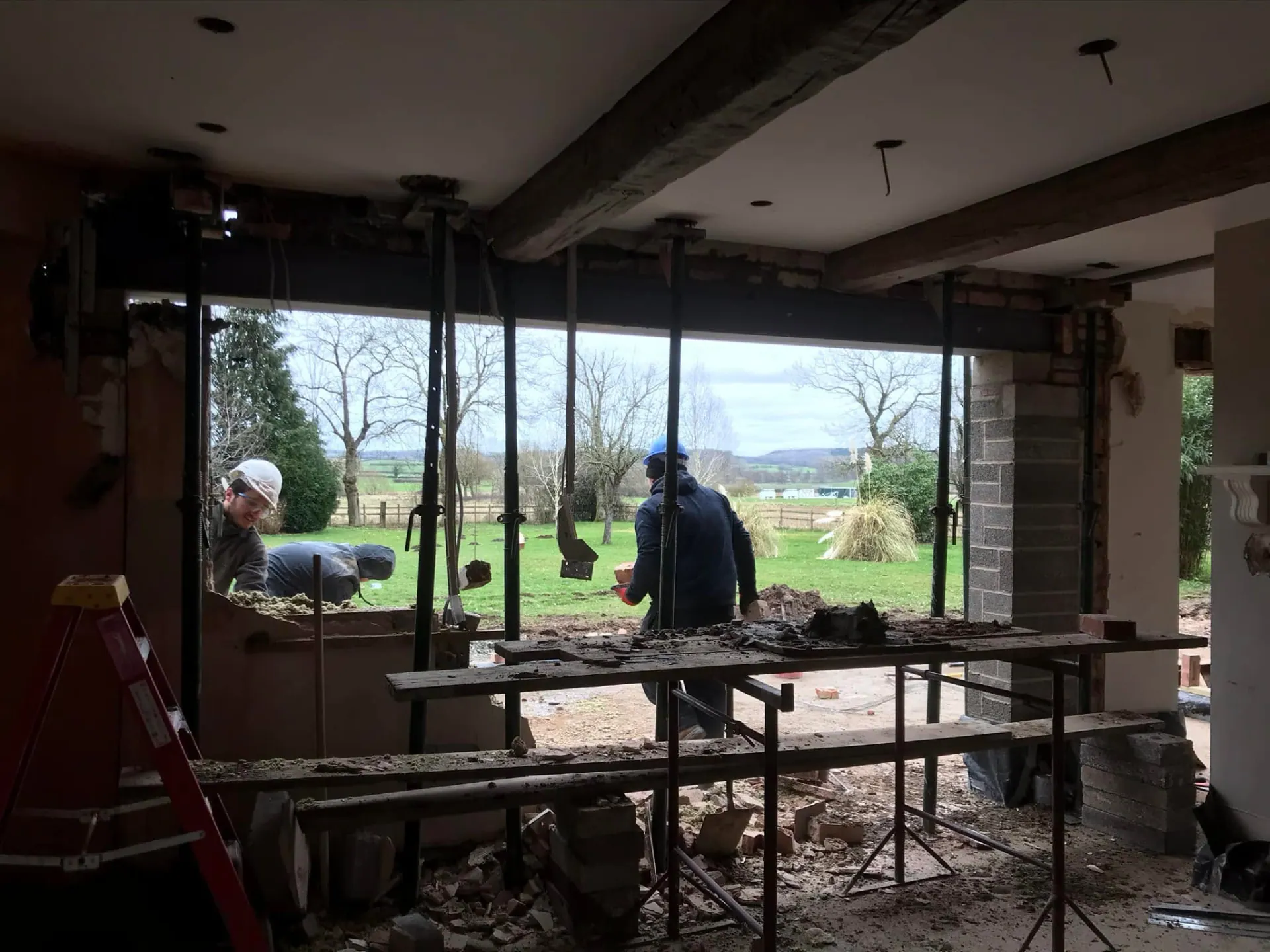 Internal structural opening with large steel beam installed and props supporting the new opening to the garden