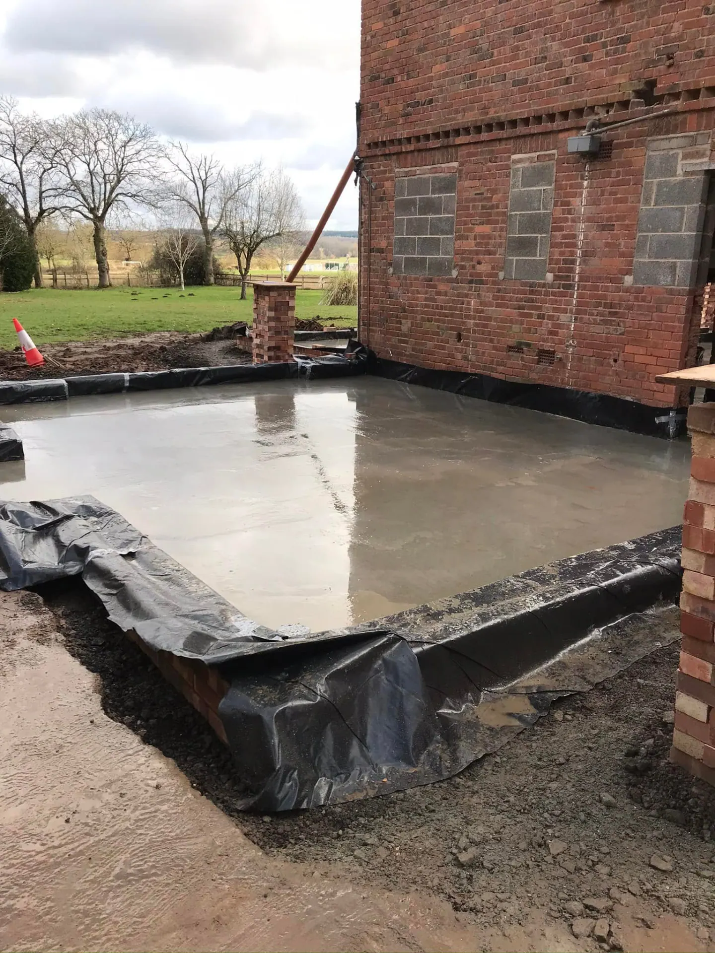Freshly laid concrete slab at the rear of the house ready for the next stage of extension works