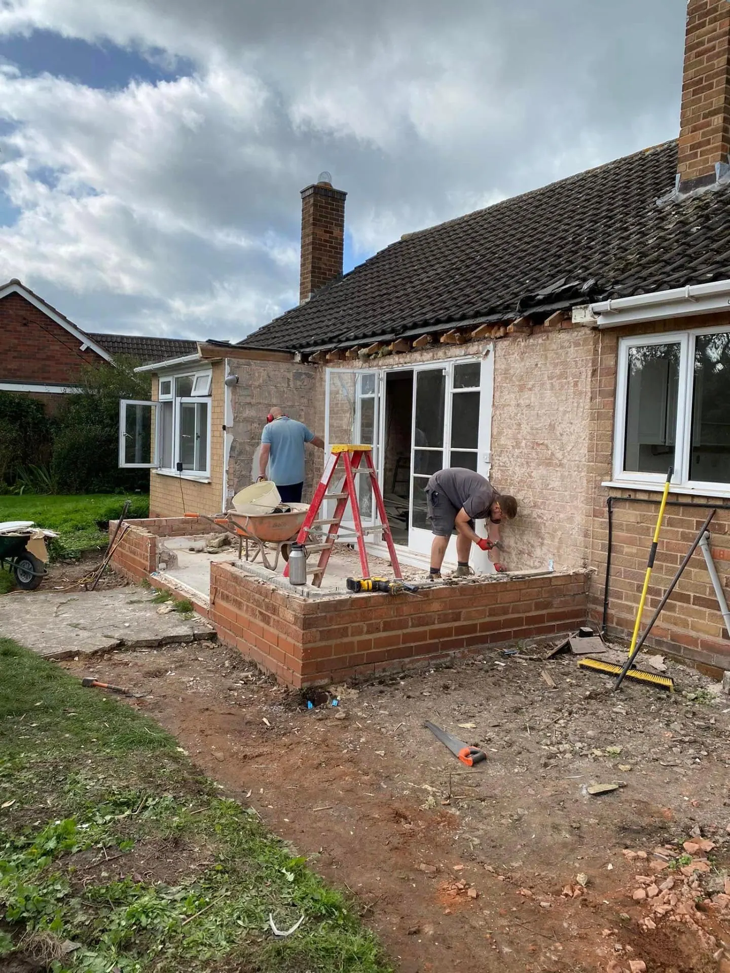 JRC crew drilling out old window openings on the rear elevation of White Gates, sub-base terrace and skips on site