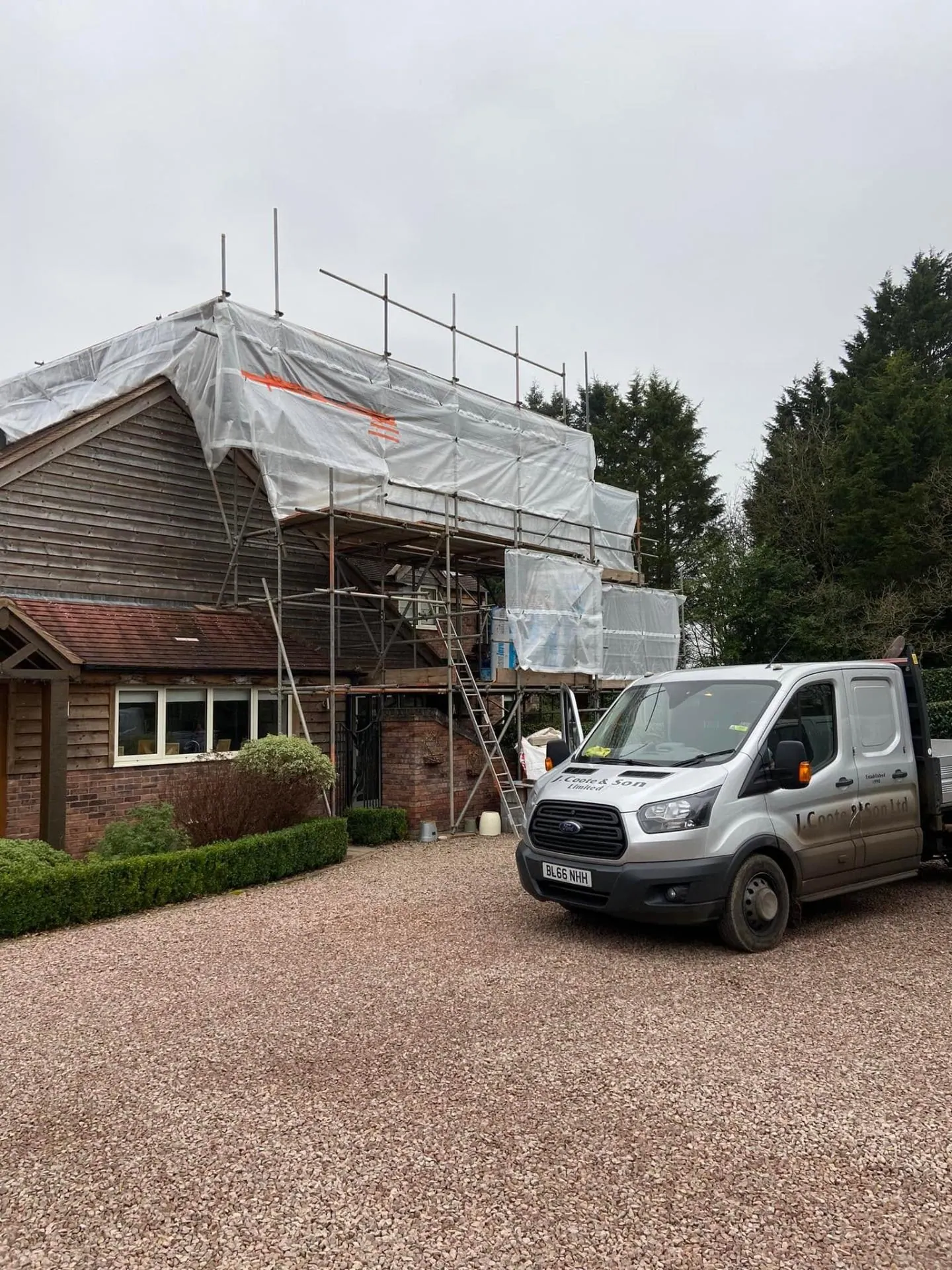 Close-up of the shrink-wrap scaffold tent over the future oak-clad gable at Dingleside, with the existing timber-clad gable of the original house visible below — JRC Developers