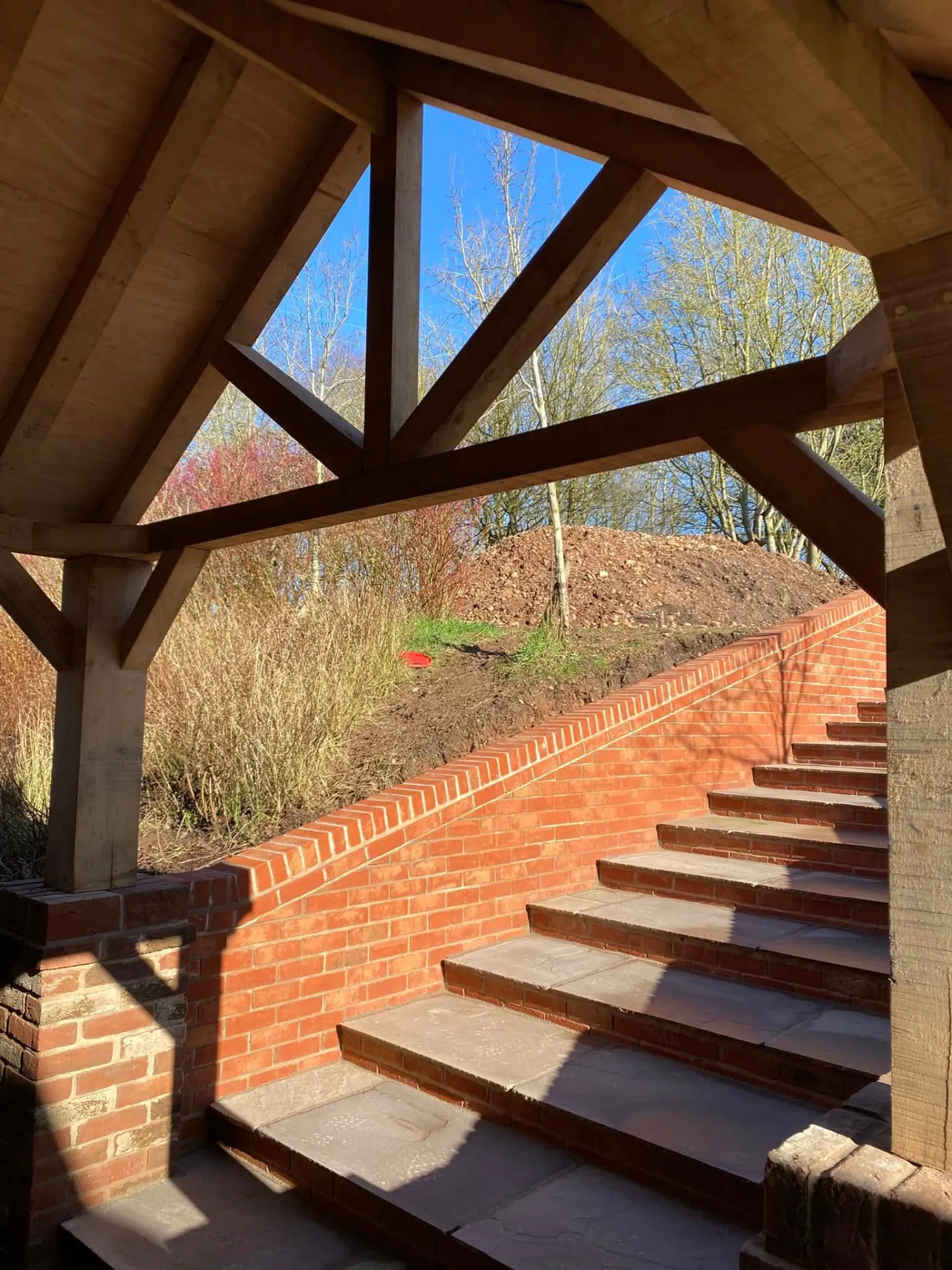 View up through the hand-cut oak trusses of the new porch towards the brick steps and sandstone treads