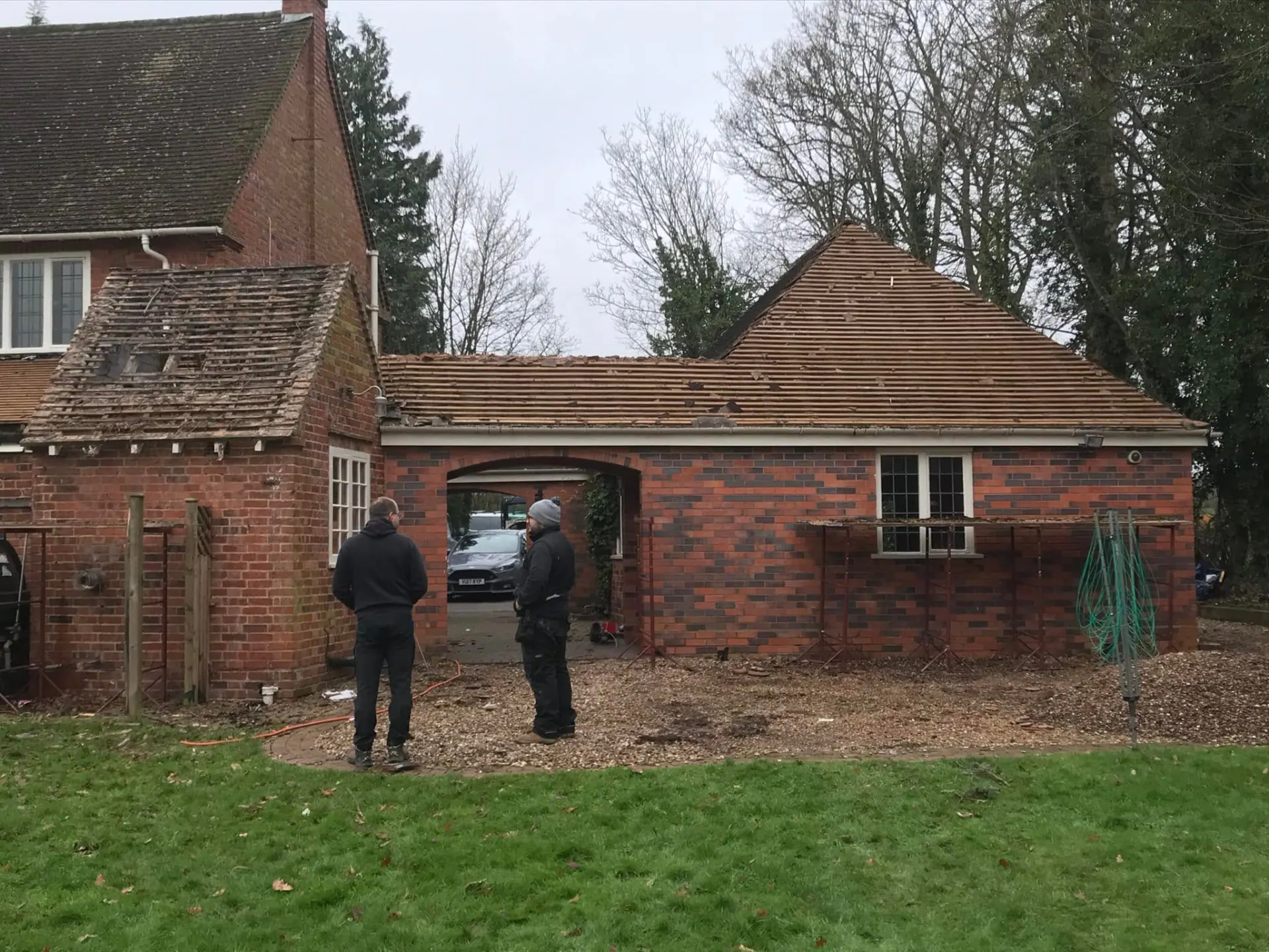 The old outbuilding and garage area mid-way through remodelling with stripped roof and new walling visible