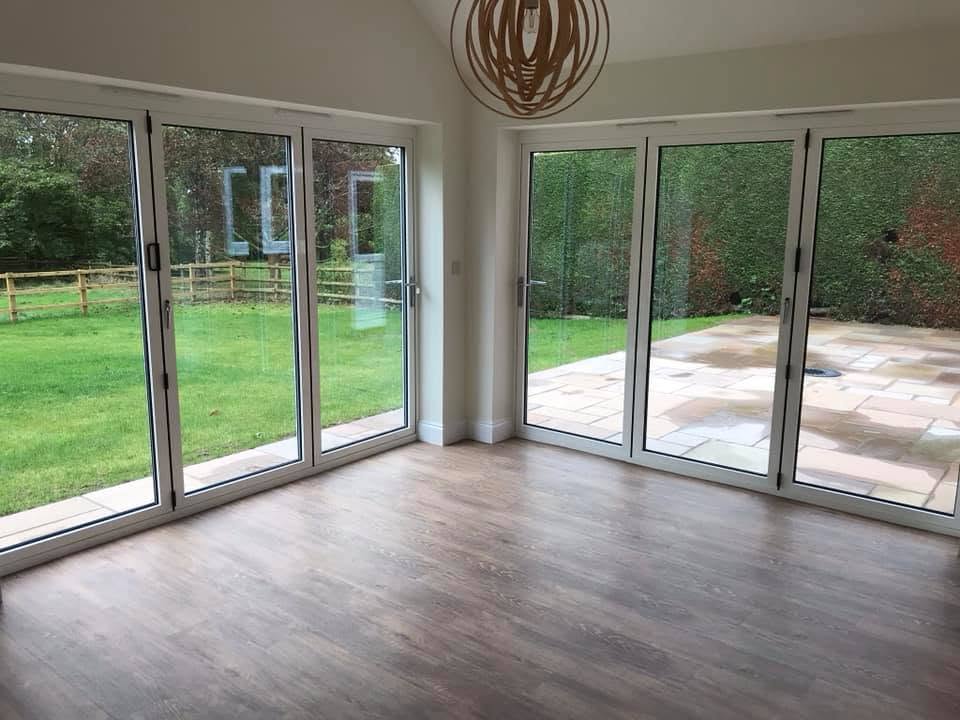 Interior lounge view showing exposed vaulted roof structure and two sets of bifold doors