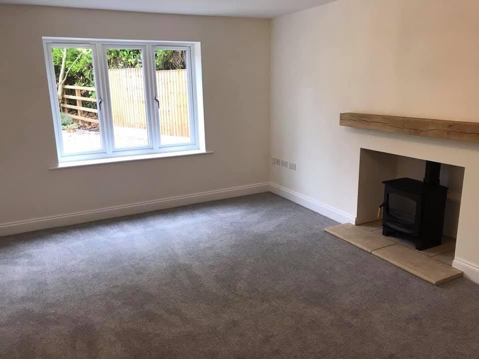 Second reception room at the Inkberrow new-build with carpet and log burner