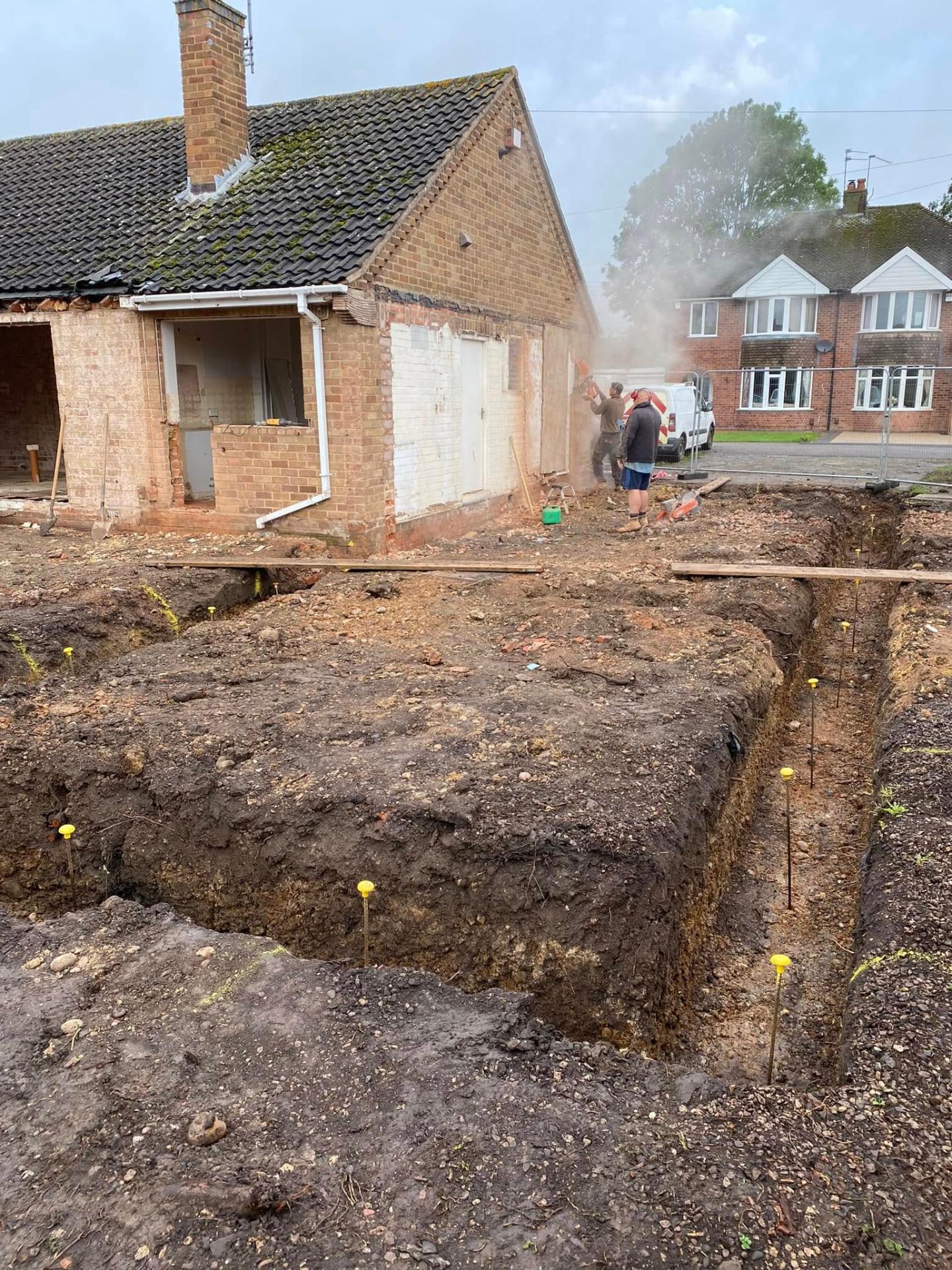Deep foundation trenches at White Gates with yellow datum pins