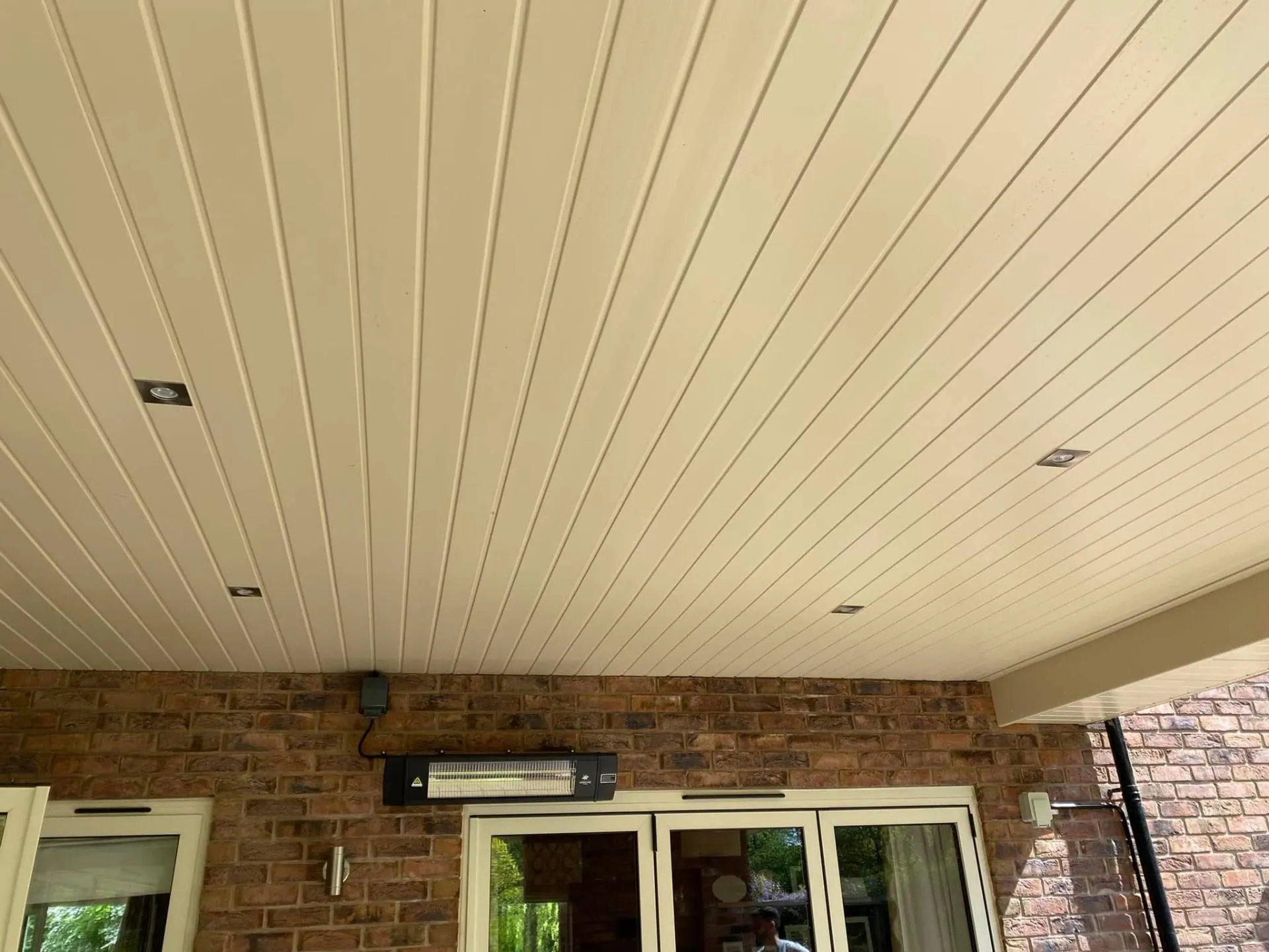 Painted tongue-and-groove terrace soffit ceiling with recessed downlights at Dingleside by JRC Developers