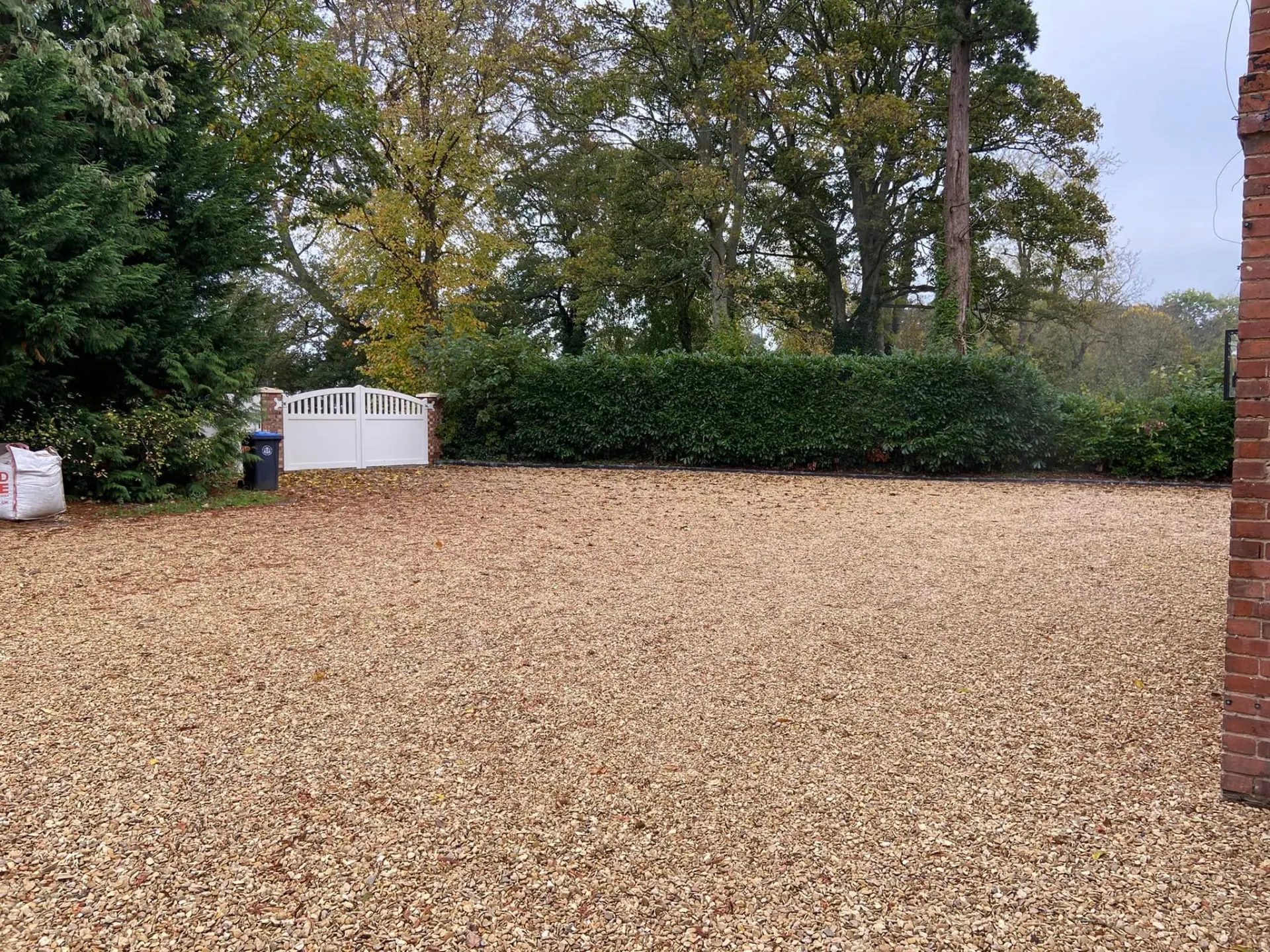 Broad gravel driveway leading to the finished house and entrance gates at Wootton Mead