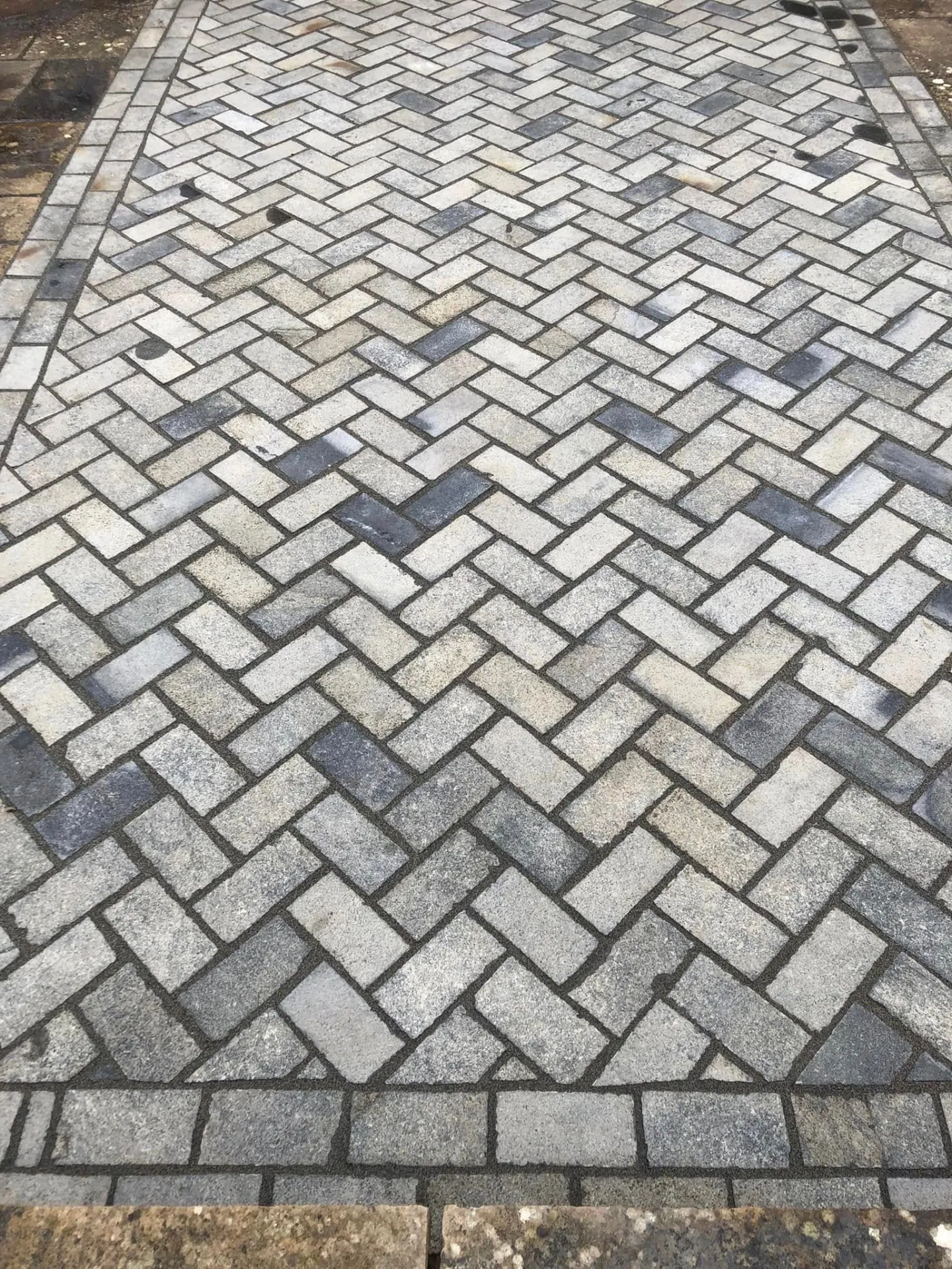 Natural limestone sett paving laid in a herringbone pattern with a soldier course border, blended grey and buff tones, on a Worcestershire terrace