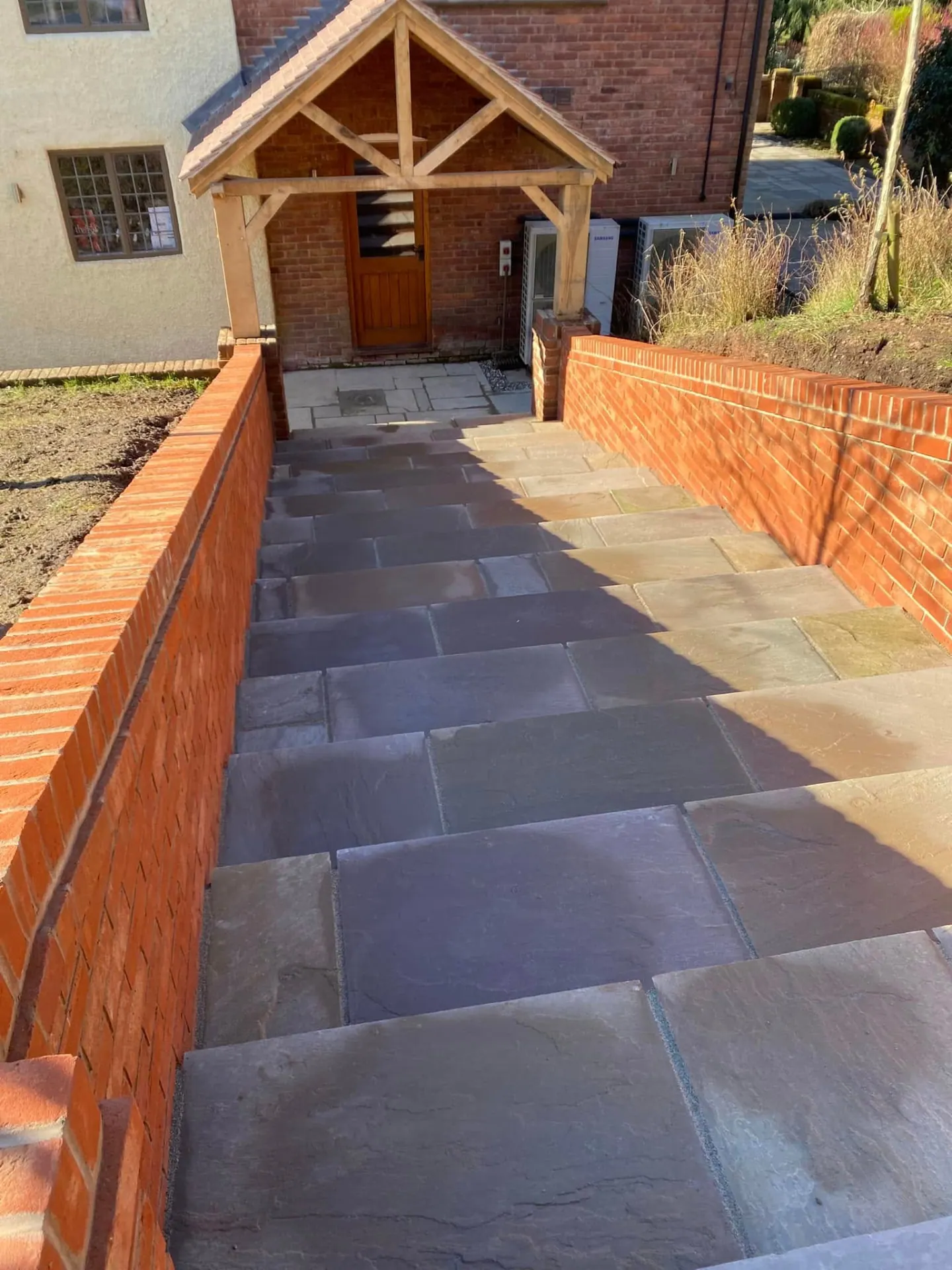 Looking down the new sandstone path and steps towards the oak porch and side door of the Worcestershire house