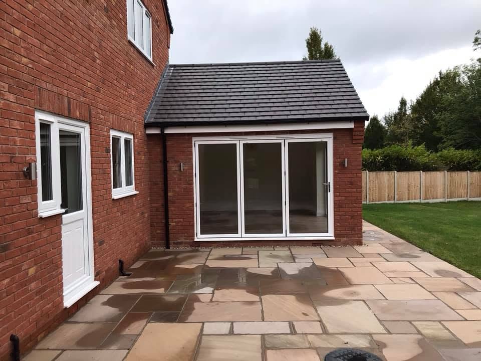 Sandstone patio against the red brickwork of the Inkberrow new-build