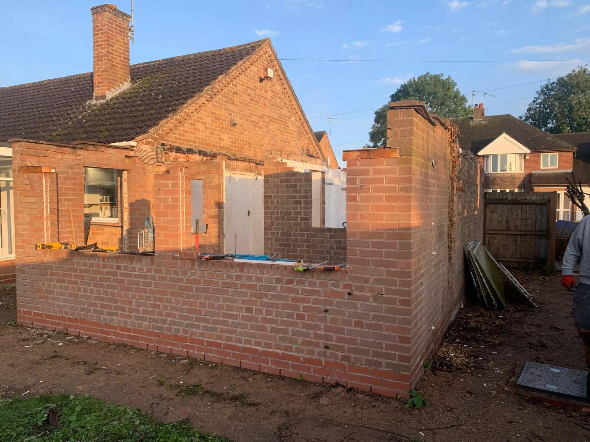 New side wall brickwork progressing at White Gates with reveals cut for windows and doors, existing chimney behind