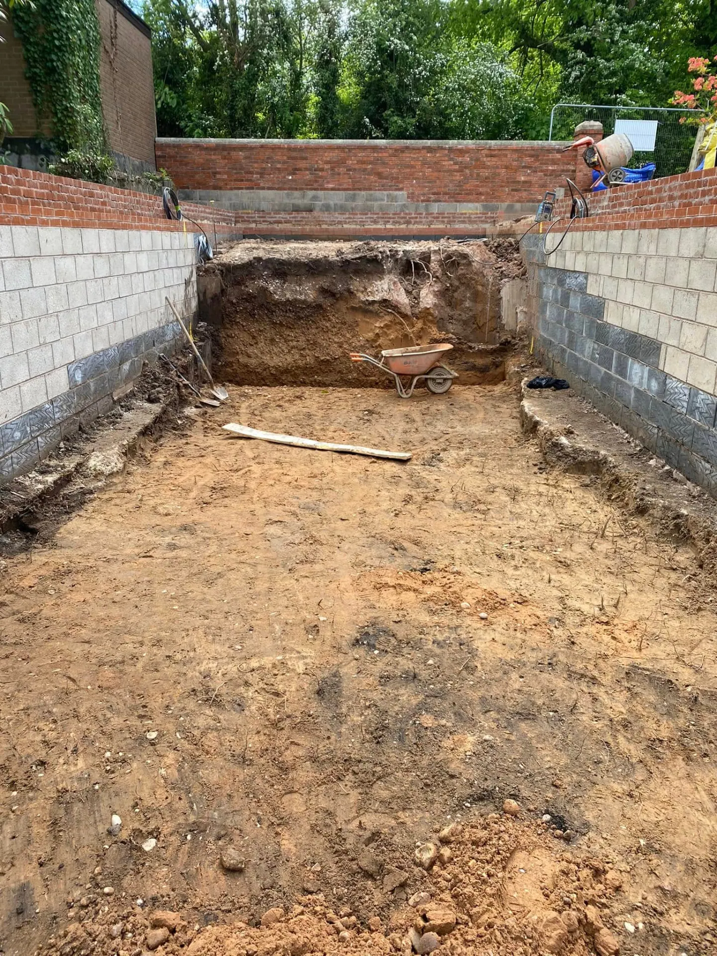 Excavated and levelled footprint at Whiteoaks surrounded by tiered reclaimed brick and blockwork retaining walls