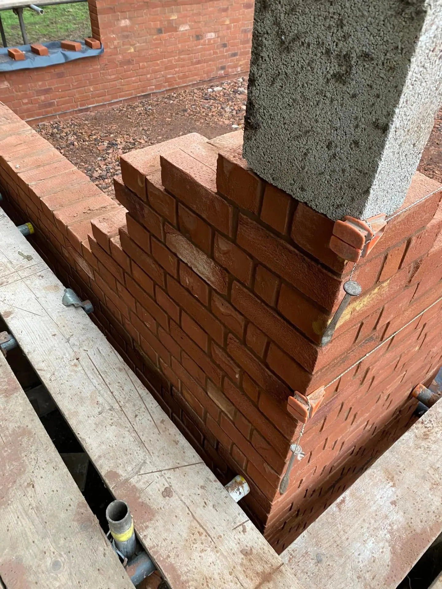 Close-up of toothed cavity brickwork at a corner of the man cave showing wall ties, insulation and a stepped racking back