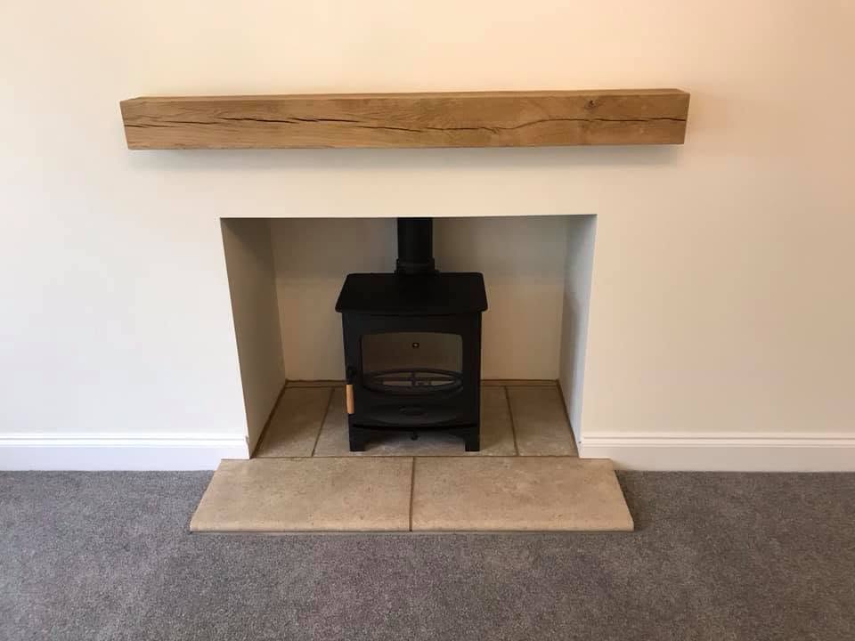 Log burner in the Inkberrow lounge with oak mantle