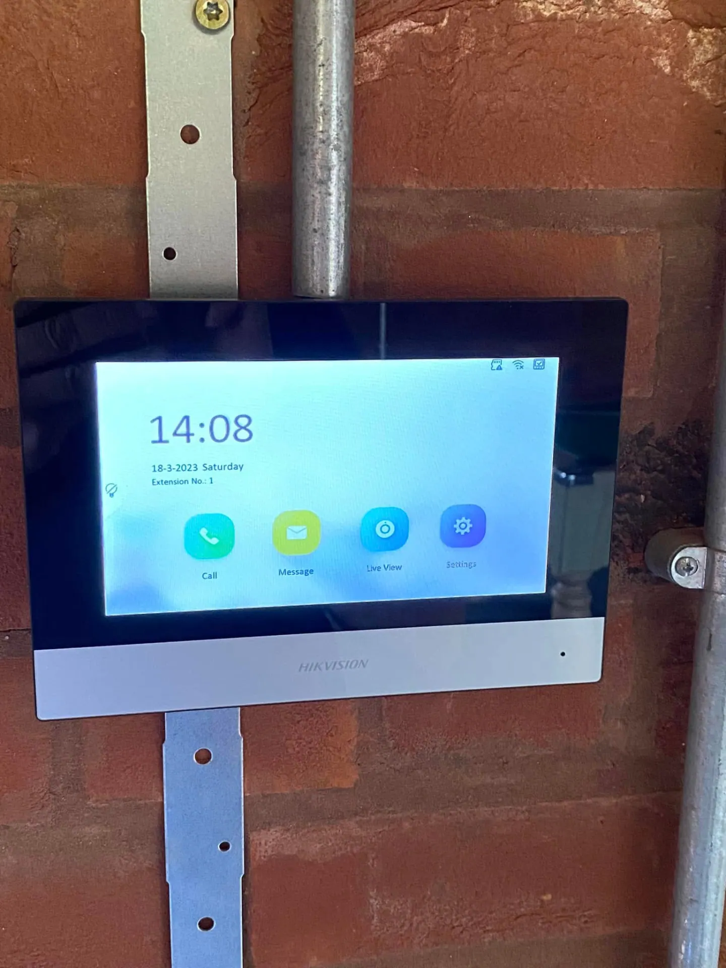 Hikvision intercom monitor installed on the internal brick wall of the man cave with surface conduit